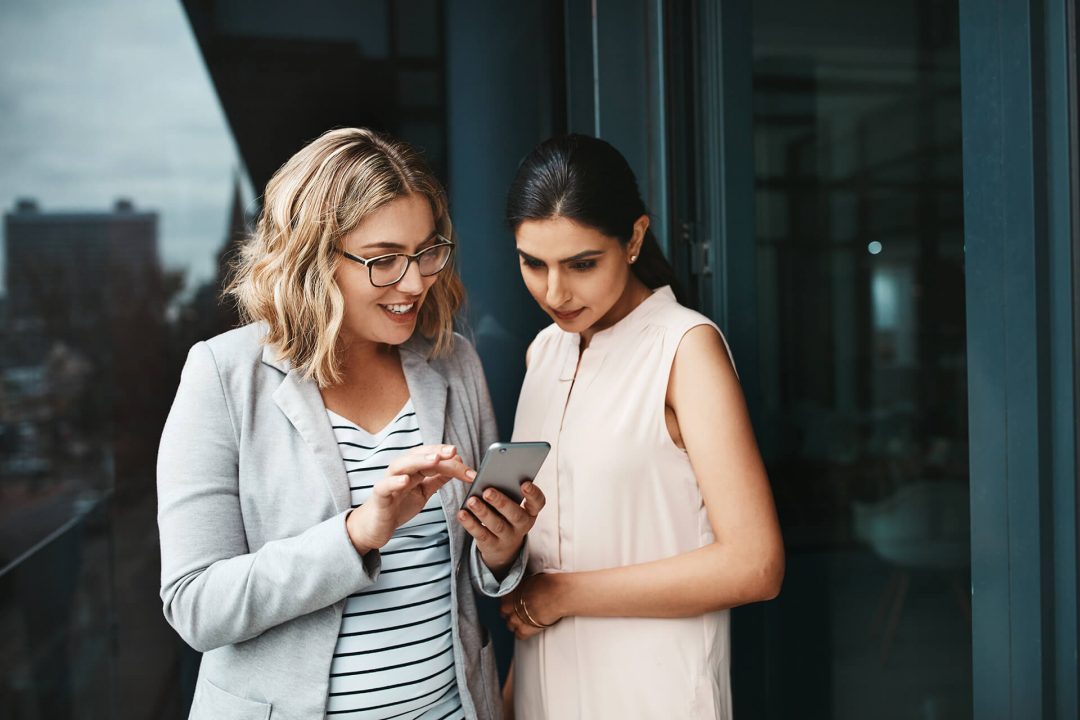 Two women looking at a mobile phone